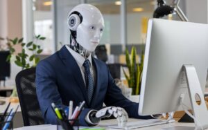 רובוט יושב מול מחשב מבצע עבודה במחשב